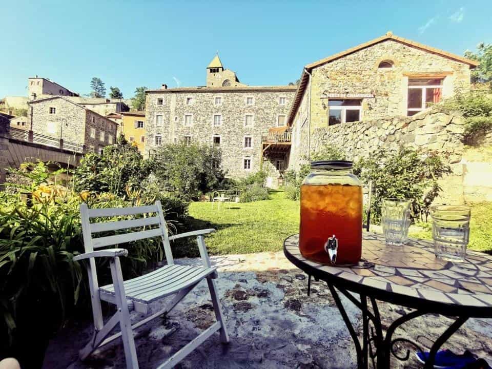 Iced tea dispenser and glasses on patio table outside Auberge de Chanteuges.