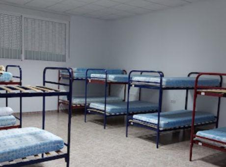 Bunk beds with blue mattresses in a sparse room at the municipal hostel in Vilamartín de Valdeorras.