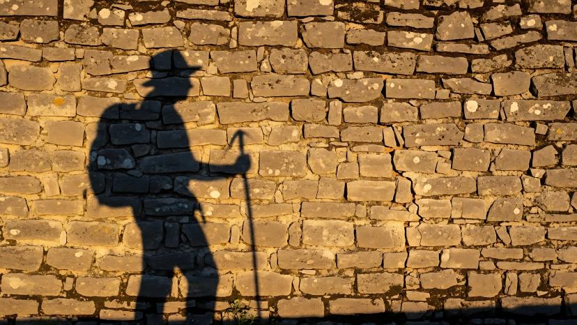 Hiker Shadow on Stone Wall: Pilgrimage Route