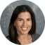 Smiling woman with long dark hair against a gray background.