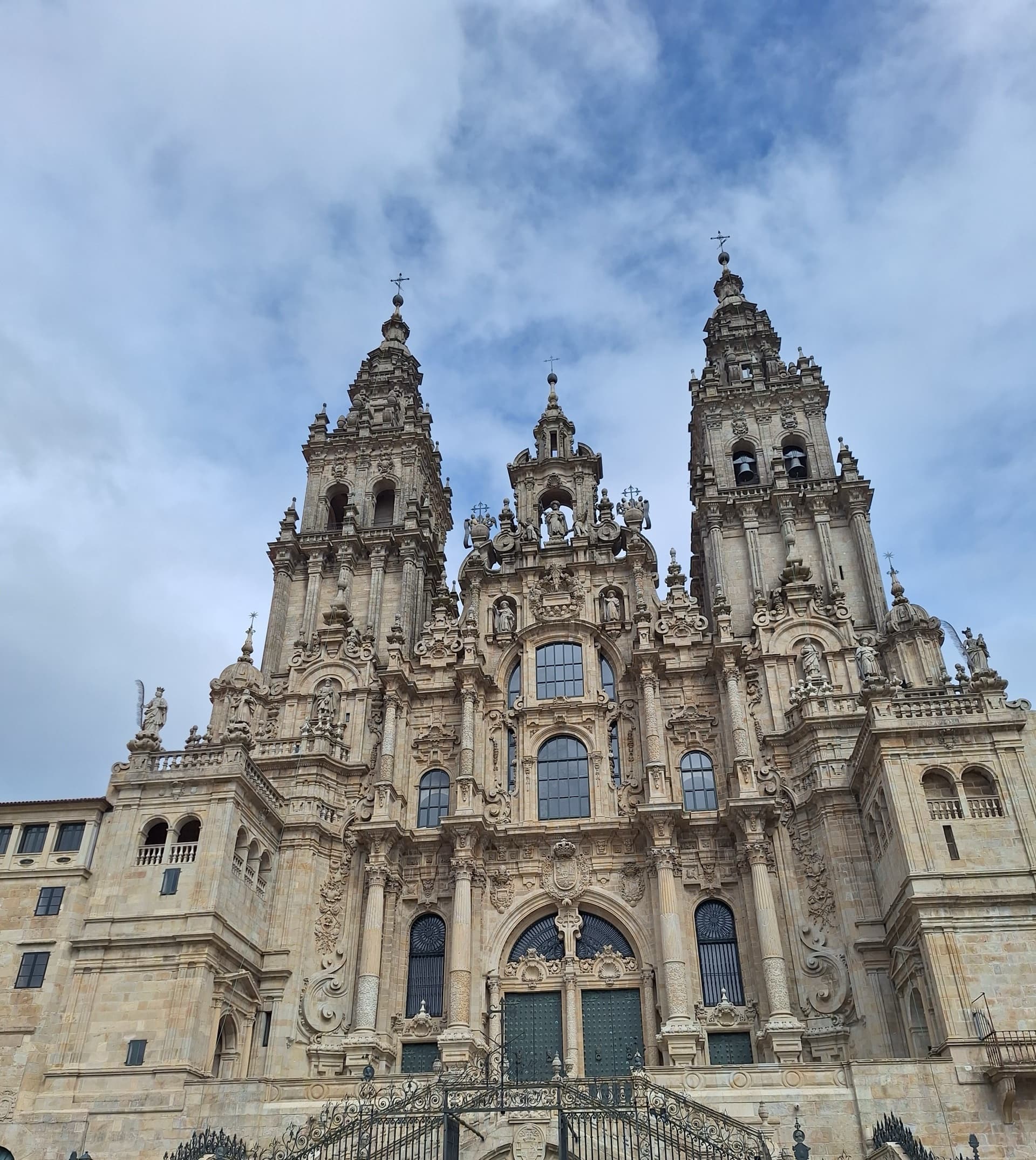 Ornate cathedral facade with twin towers against a cloudy sky