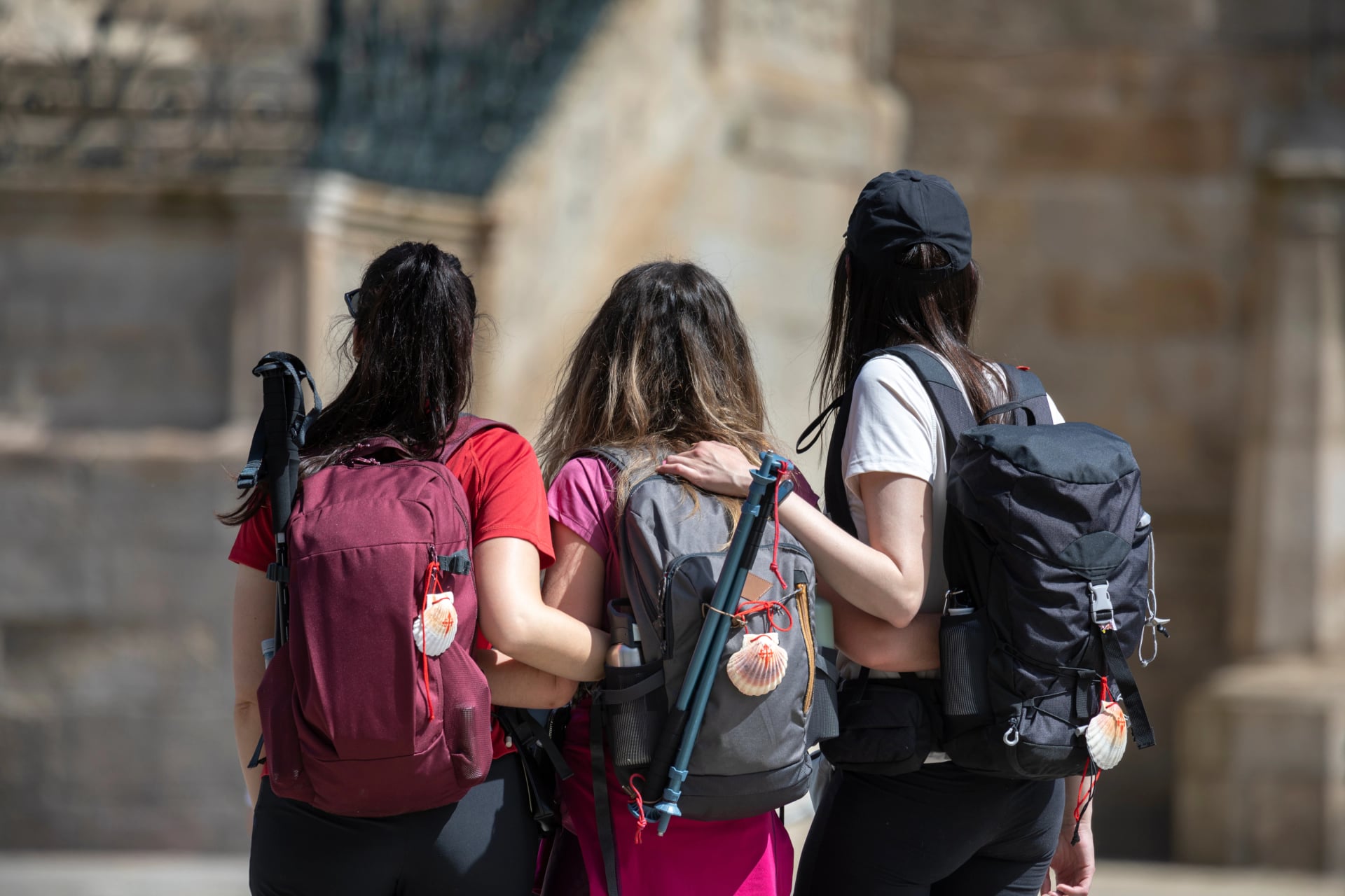 Pilgrims from the Camino de Santiago arrive at the Plaza del Obradoiro because they have finished their pilgrimage
