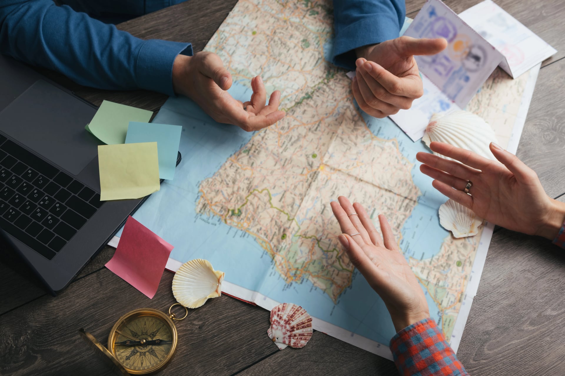 discussie en controverse bij het plannen van reizen. Koppel dat Europa kaart onderzoekt. Bovenaanzicht. Tafel met kaart, handen en kompas