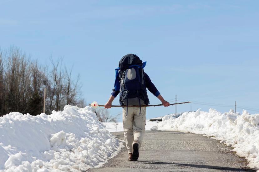 pilgrim in winter with snow in way of St James, Camino de Santiago, Compostela, Spain