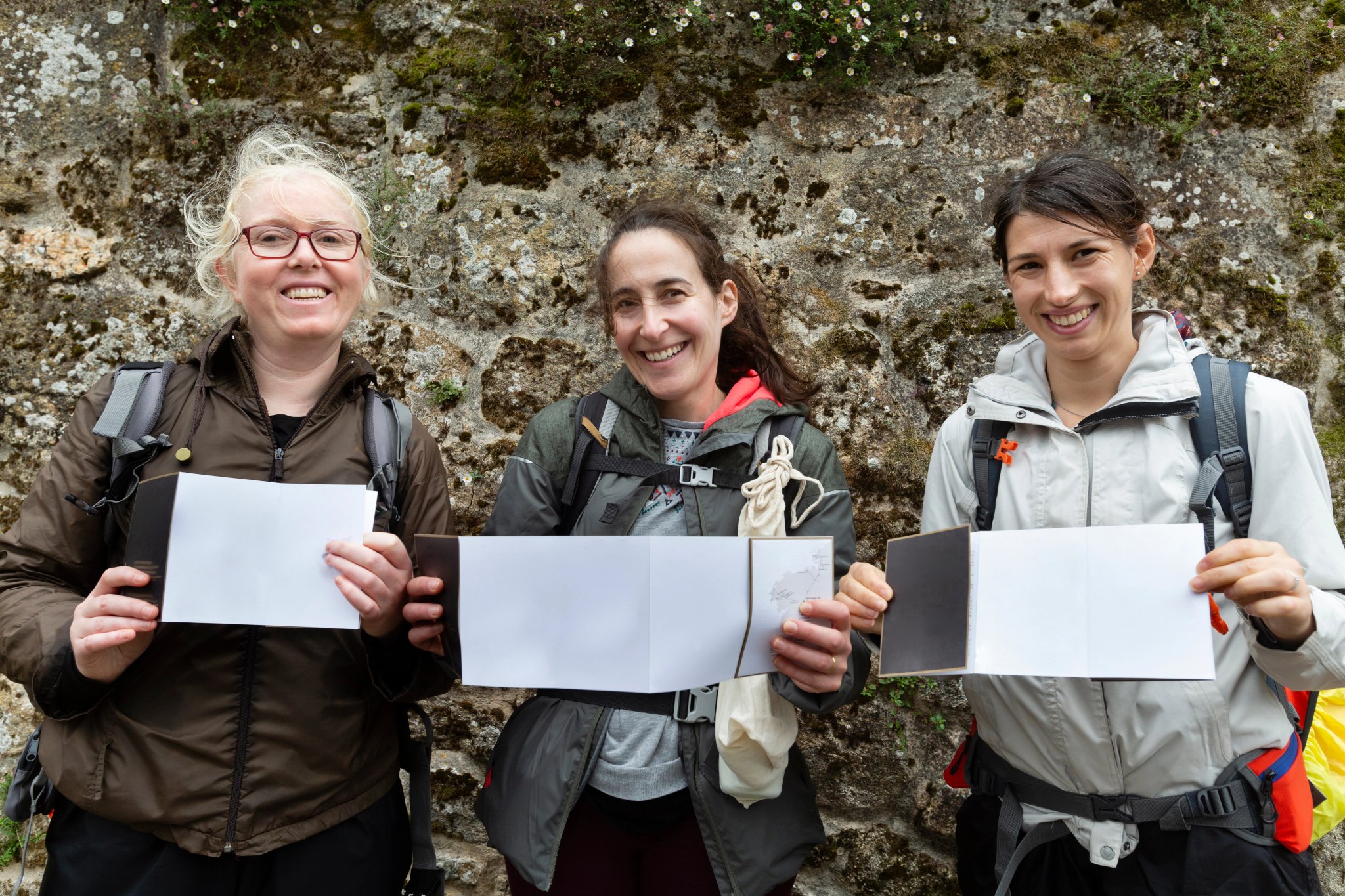 Three pilgrims show their pilgrim credentials. Camino de Santiago portuguese