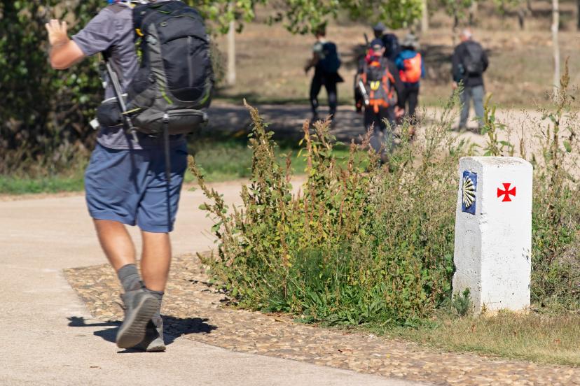 Camino de Santiago group of pilgrims unfocused to Compostela , near Astorga village in Leon , Spain