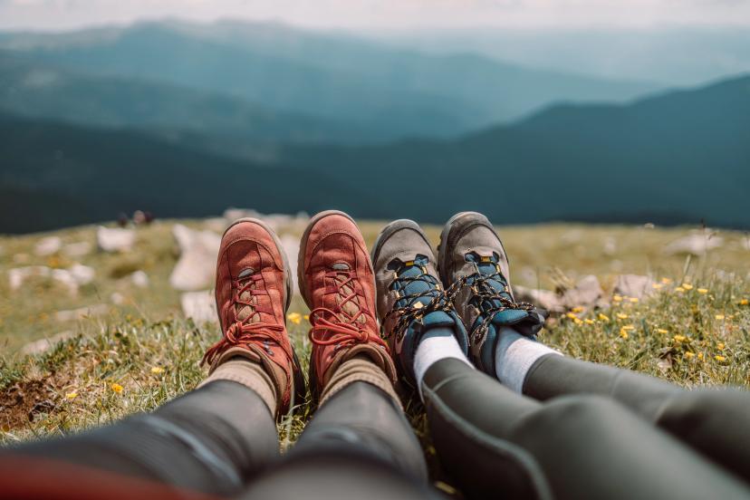 Couple of friends hiking foot hiker in front of a panoramic mountain scenery, vacation concept