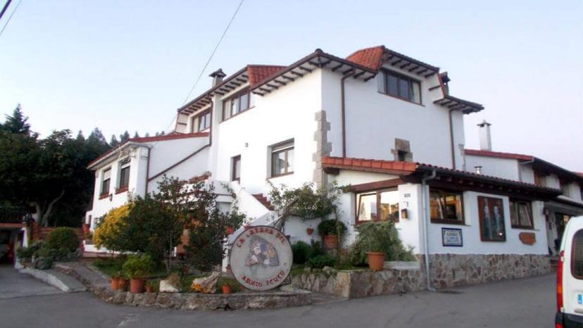 Albergue de Peregrinos de Güemes, a white building with a red tile roof and stone accents.