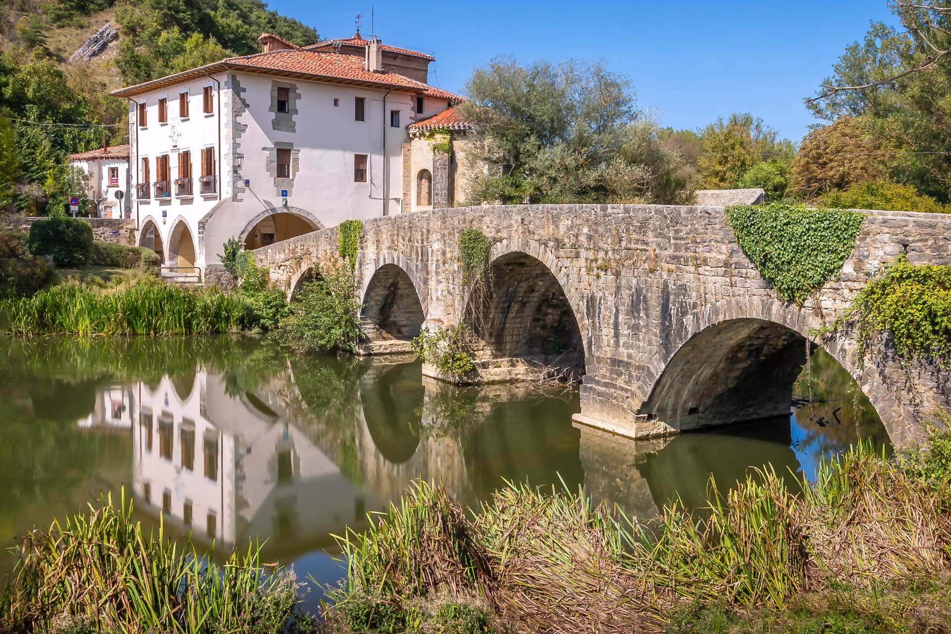 Vue du pont médiéval sur la rivière Ulzama et de la basilique adjacente et de l'albergue pour pèlerins sur le chemin de Saint-Jacques