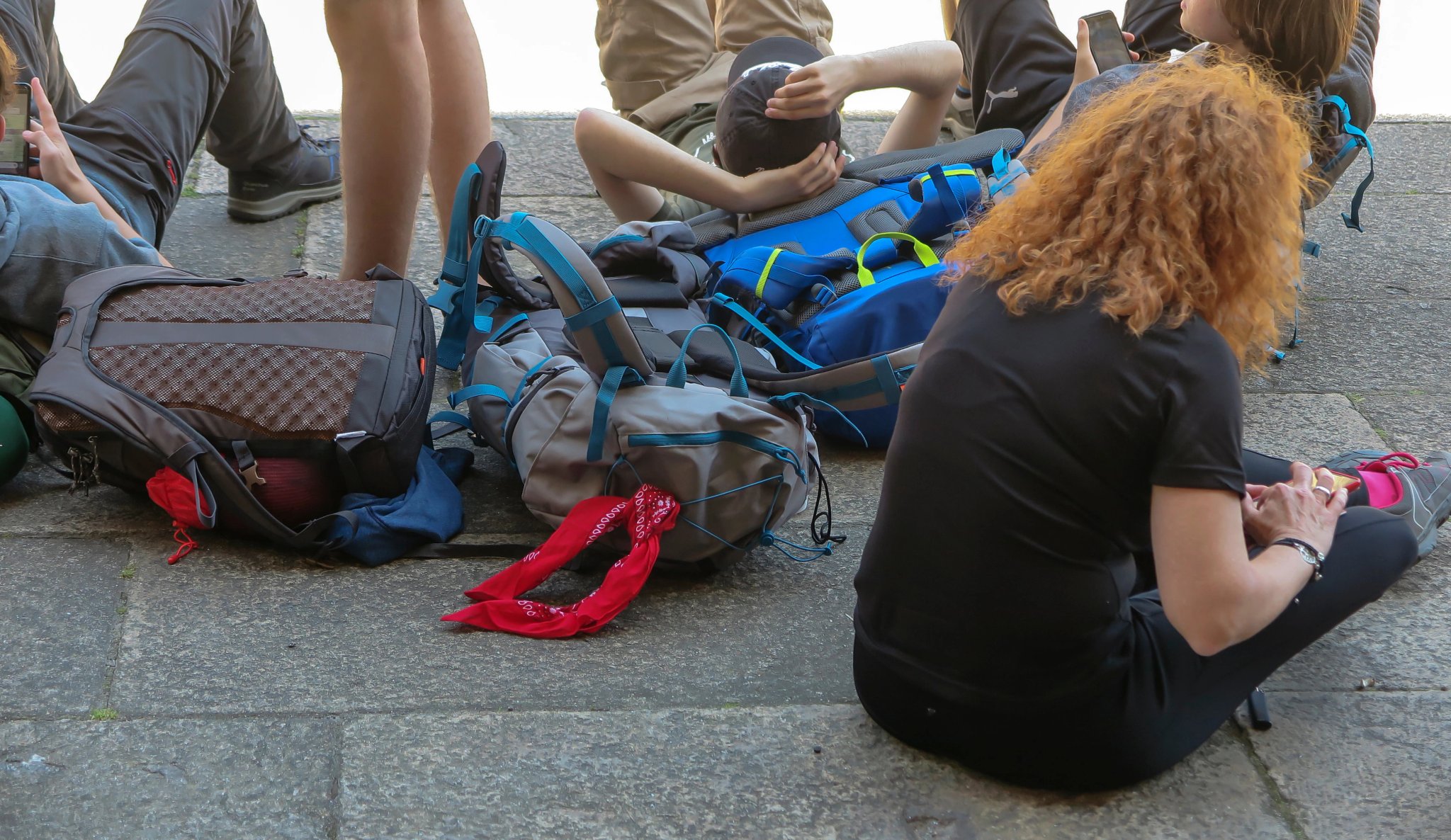various backpacks lying on the pavement
