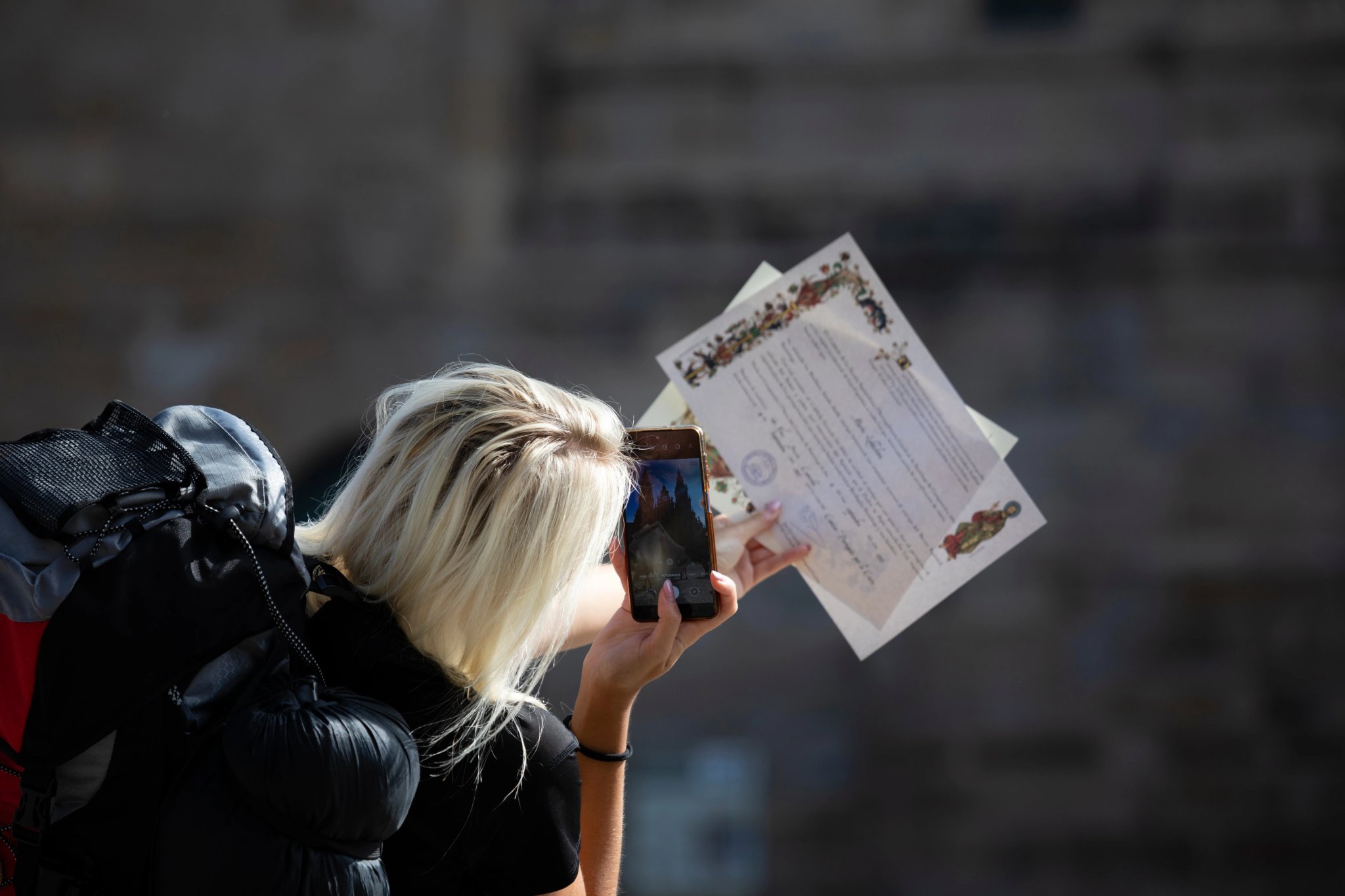 Pilgrims from the Camino de Santiago arrive at the Plaza del Obradoiro because they have finished their pilgrimage