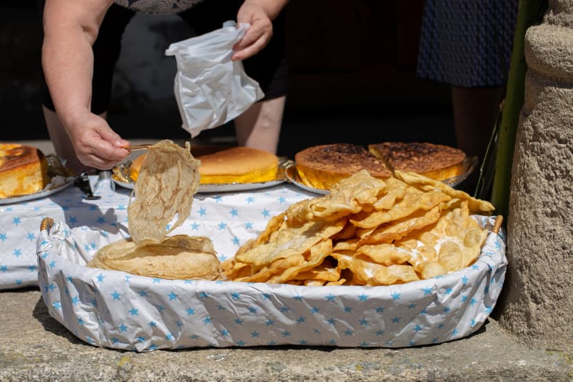 A woman is serving filloas and orejas, traditional dessert in carnival in Galicia (Spain)