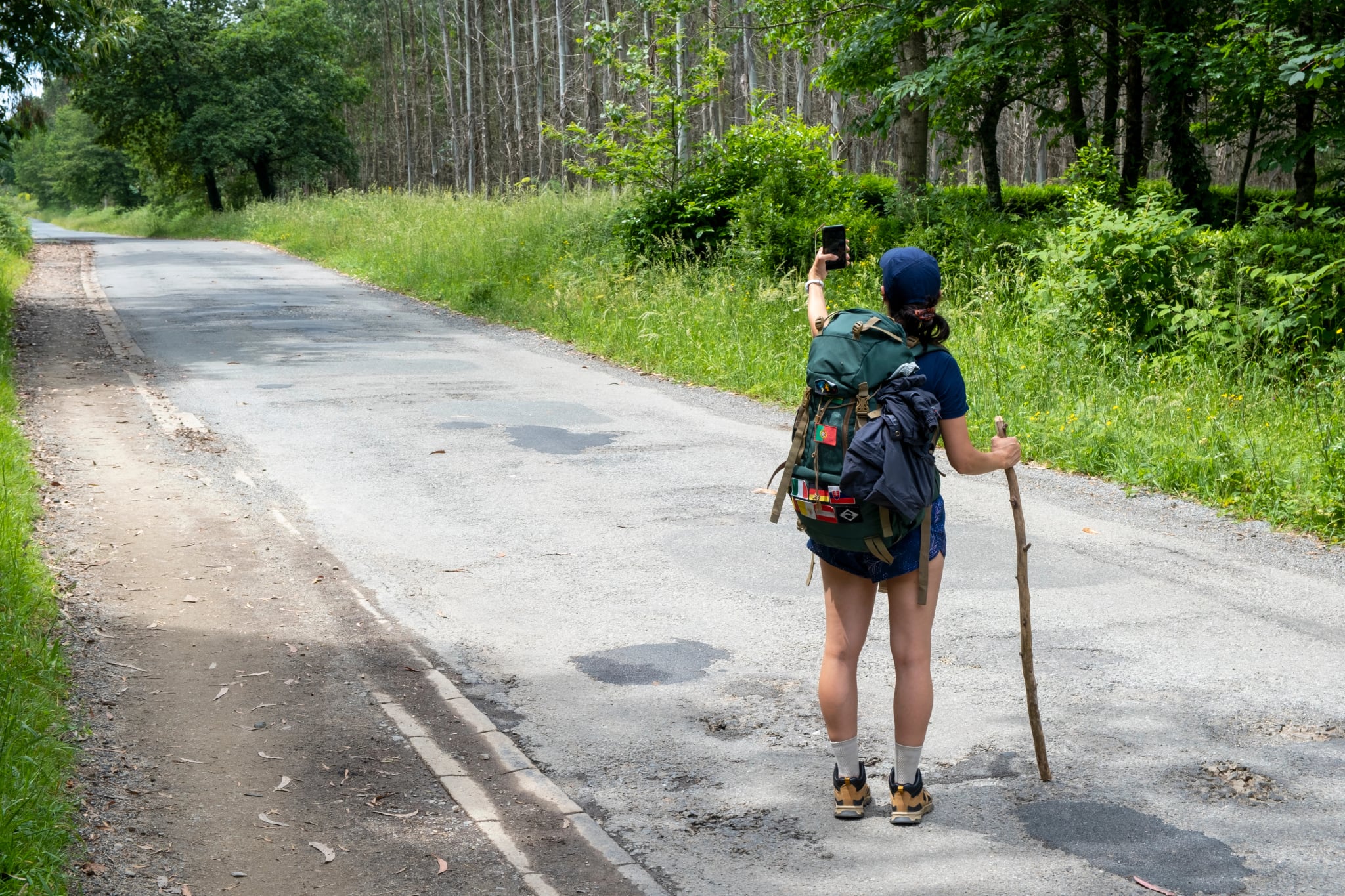Junge Frau, die ein Selfie auf einem Weg des Jakobswegs macht. Camino de Santiago