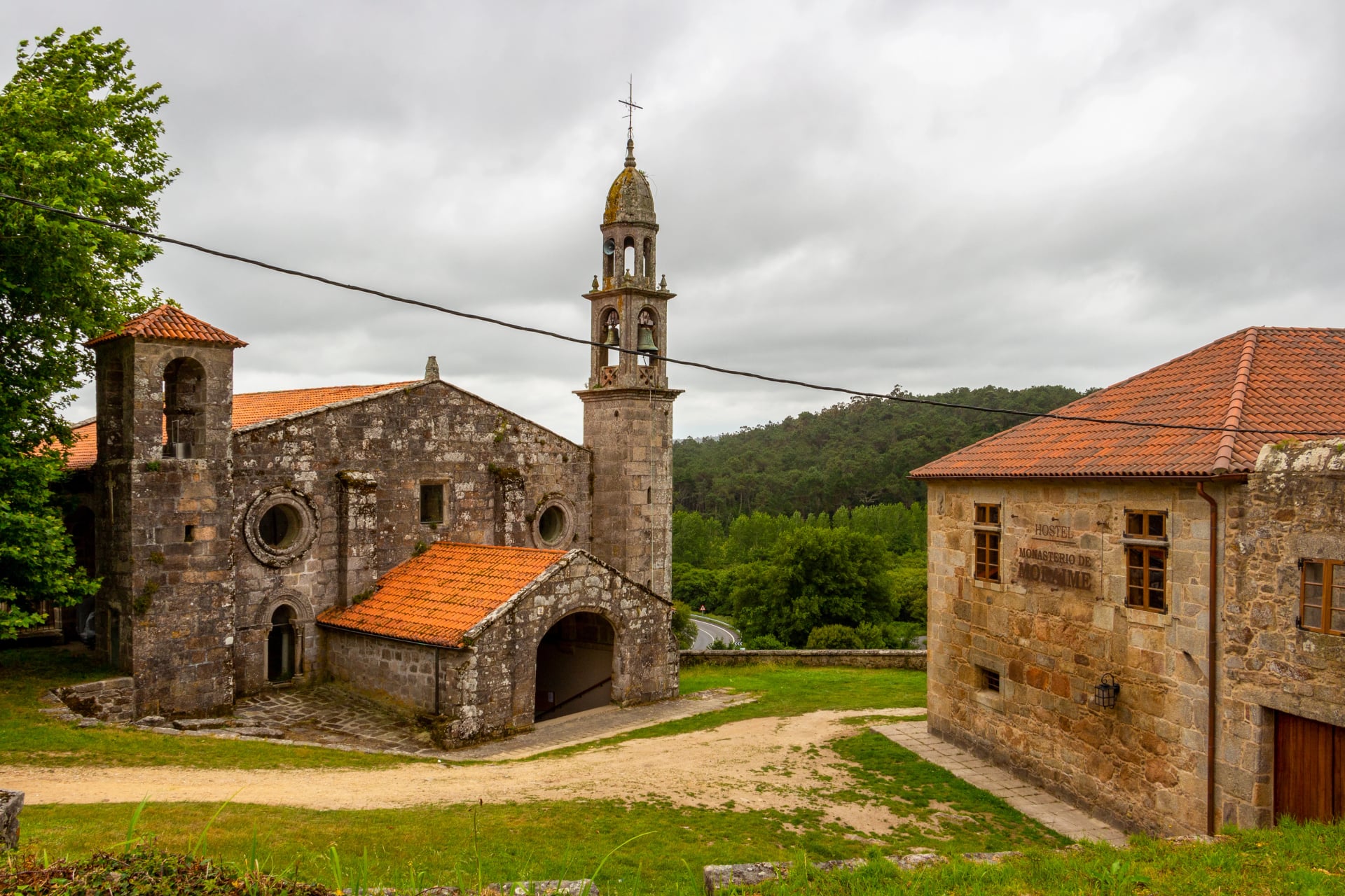 Igreja de San Xulian de Moraime com o Albergue Monasterio de Moraime à direita no Caminho de Fisterra-Muxia de Santiago em Moraime, Galícia, Espanha