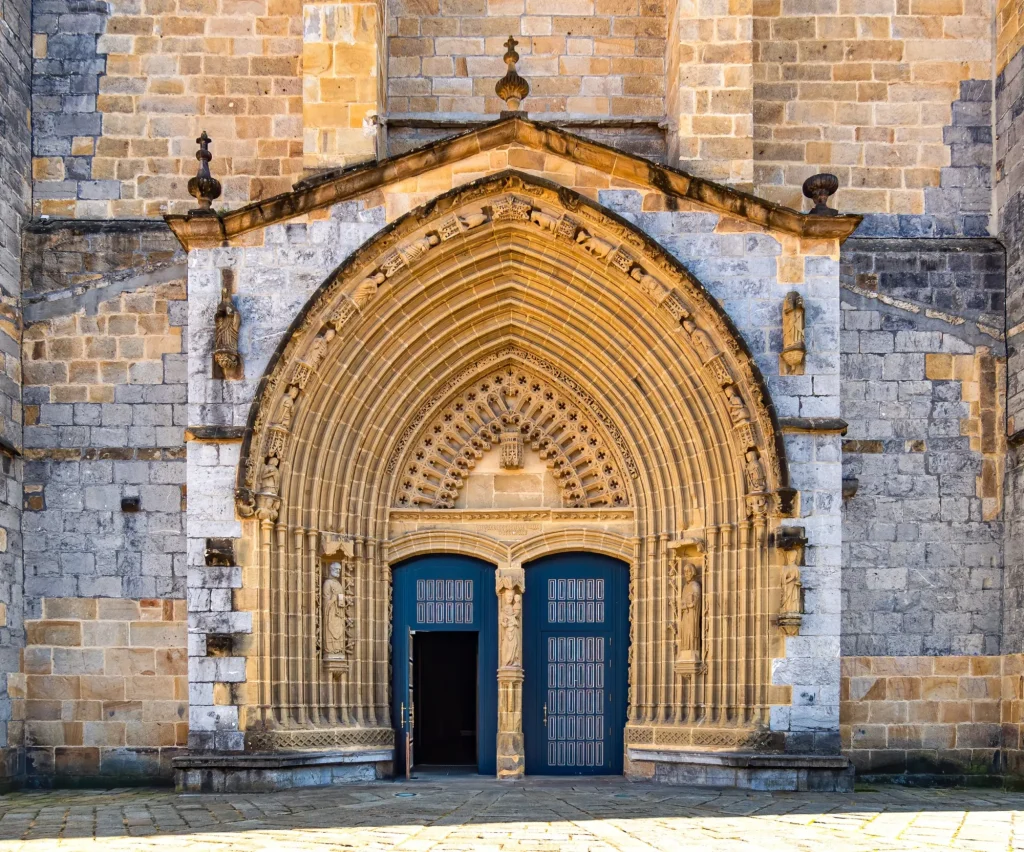 Entrance door and main facade of old stone church in Guernica, Basque Country, Spain. Romanesque architecture concept. Religion and faith concept. Facade of antique castle in Europe.