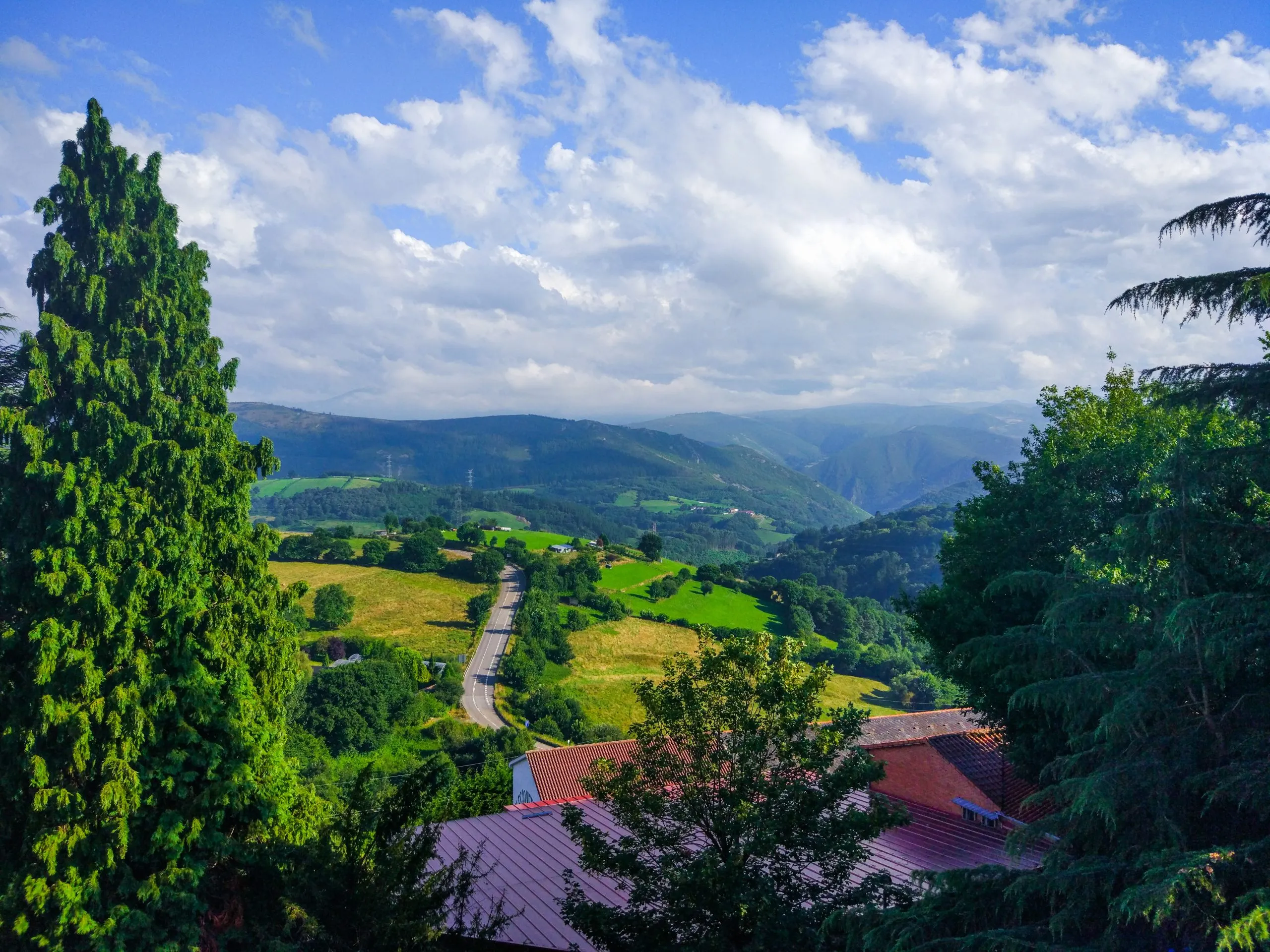 View of a highway from Tineo, Asturias, Spain, crossing a green grass valley. Camino de Santiago Primitivo